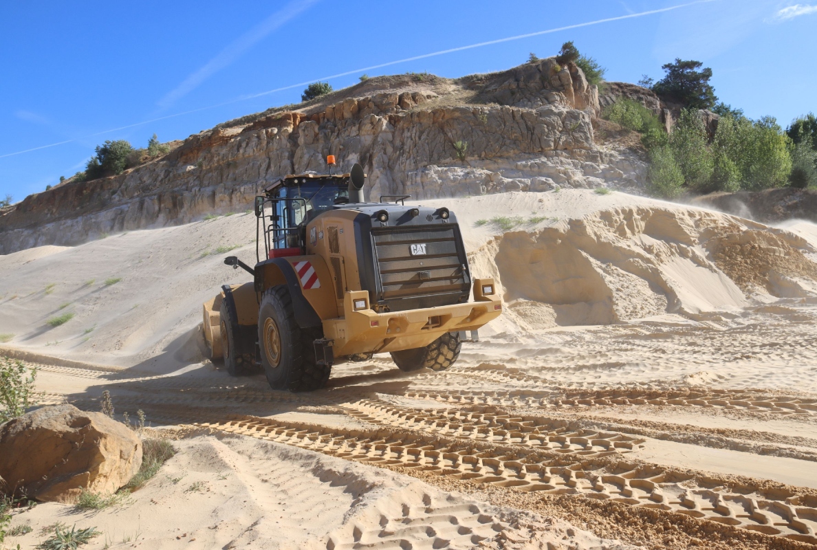 Ein neuer Cat Radlader 980 XE nimmt den Rohsand im Load-and-Carry-Betrieb auf.