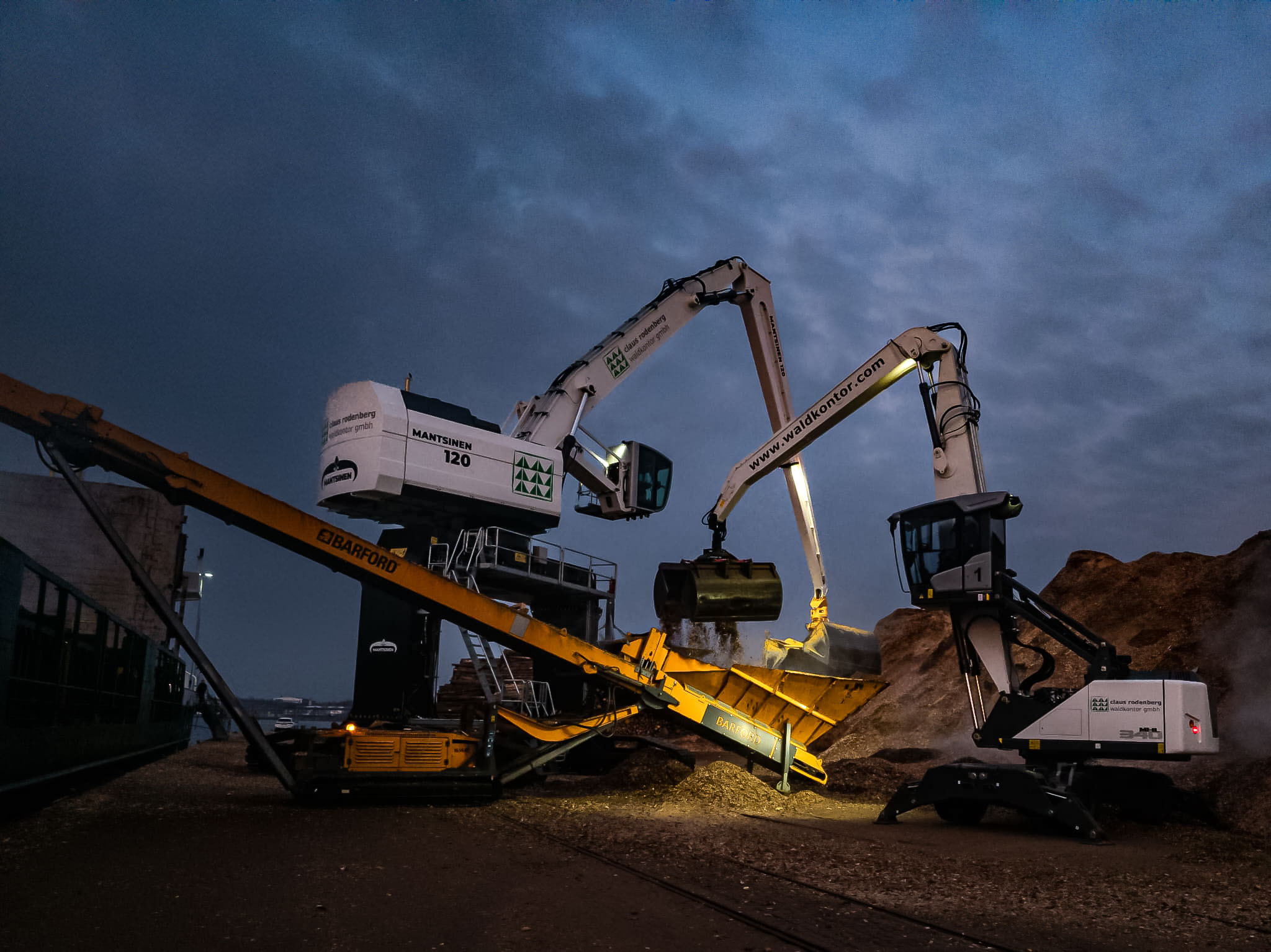 Mantsinen 120R und Fuchs MHL340F im gemeinsamen Einsatz beim Umschlag von Holzhackschnitzel.