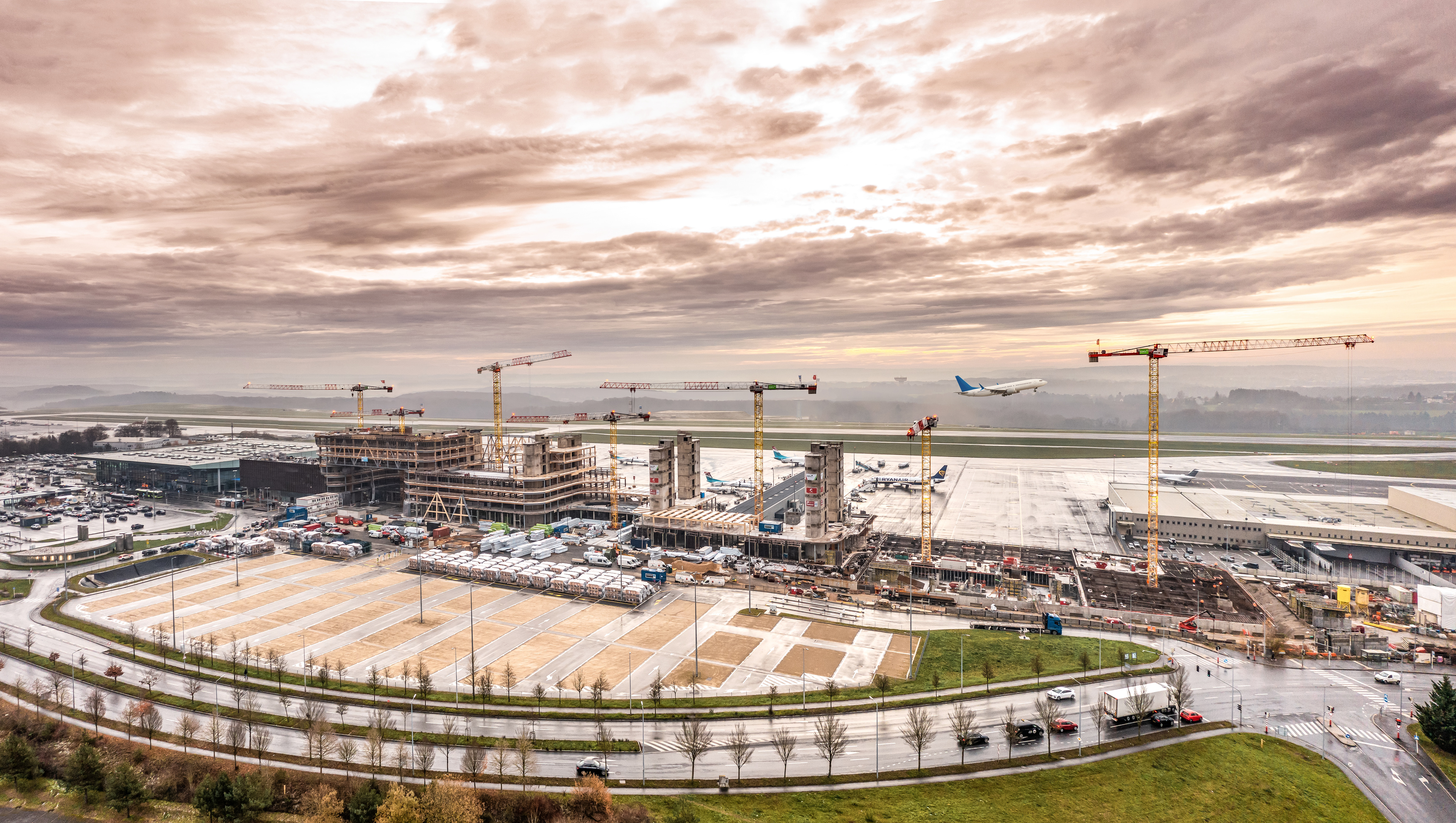 Sieben Flat-Top Krane von Liebherr unterstützen beim Bau eines Bürogebäudes am Rollfeld des Flughafens Luxemburgs.
