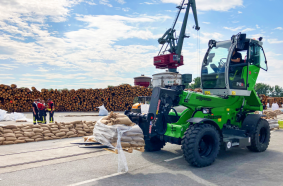 Ein Sennebogen Teleskoplader transportiert Sandsäcke auf dem Hafengelände.