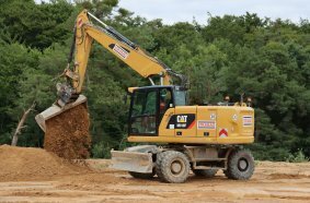 Ein Cat Mobilbagger M318F bearbeitet das Zwischenlager. 