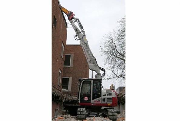 Der eingehobene Takeuchi TB 2150 CV vor einer der Wände die er zurückbauen muss.