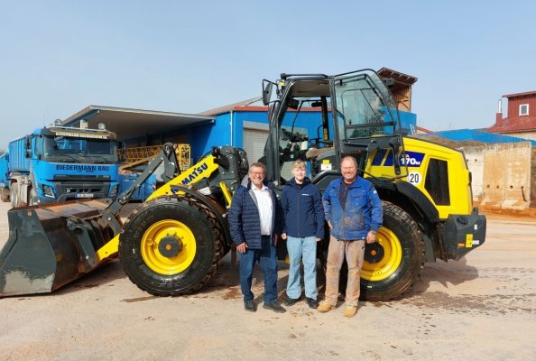 Inhaber Frank Biedermann (re.), Sohn Moritz und Kuhn Vertriebsleiter Jochen Beißwenger (li.) bei der Übergabe des neuen Komatsu WA170M-11 auf dem Betriebshof in Bönnigheim.